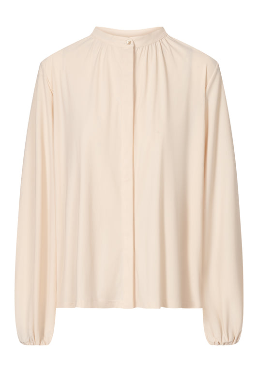 A beige long-sleeved modest blouse with a high collar and hidden buttons, designed for women.